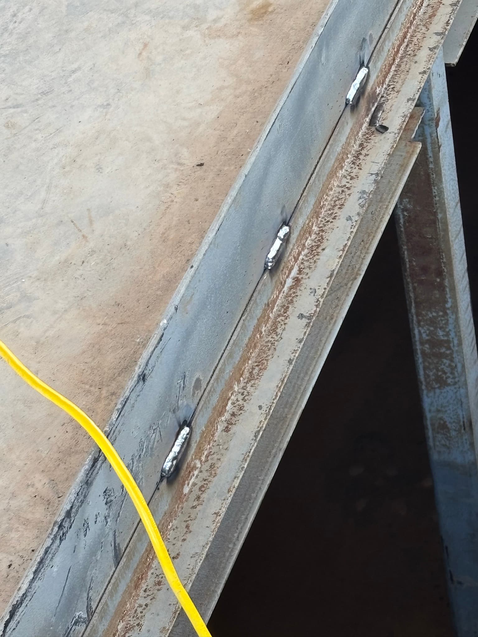 Fabricated metal outrigger tack welds